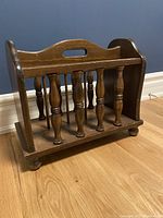 Front and side view of the vintage wooden magazine holder with spindle design and cutout handle.