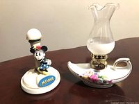 Photo showing front angles of Minnie Mouse cooker cutter and floral oil lamp on brown surface