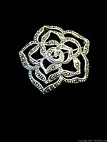 Front view showing openwork rose brooch with marcasite stones and detailed silver craftsmanship.