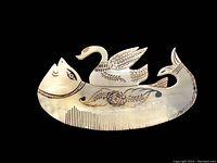 Front view of vintage carved horn fish comb featuring a swan and decorative folk art designs