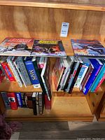 Wooden bookshelf with two Star Wars magazines on top shelf and various books underneath