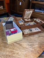 Jewellery box with various contents alongside three small wallets and additional small boxes.