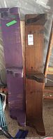 Front view of two wooden shelves side by side, one painted purple and the other natural wood, showing brackets and length.