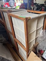 Two wood frame shoe storage racks stacked side by side, showing overall structure and size of racks with cloth compartments.
