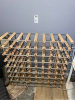 Full view of the wine rack showing the wood and metal construction and multiple compartments for wine bottles.