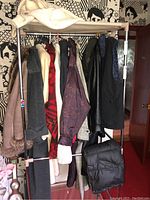 Photo showing assorted ladies clothing hanging on a rolling rack, including coats, jackets, and knitwear in various colors and patterns.