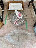 Top-down view of punch bowl, ceramic dishes, and fish-shaped glass platter on floor