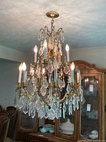 Full frontal view of brass-finish chandelier hanging in dining area