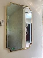Front view of beveled glass mirror showing shape, frame, and wall mounting.