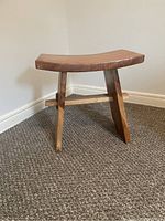 First small wood side table with angled legs and curved wooden top.