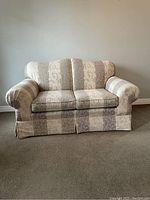 Front view of the beige and taupe brocade loveseat with rolled arms and cushioned back and seat.