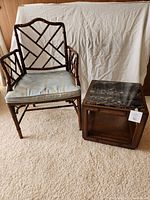 Front view of bamboo chair with Cupid print cushion and granite top side table.