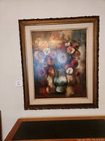 Frontal view of the floral painting in an ornate frame