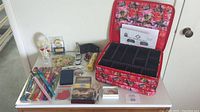 Full lot overview showing all items on white table, including jewelry organizer, money clip, napkin rings, book light, luggage tags, chopsticks, wallets and bath salt shaker.