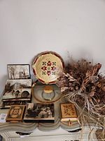 Full view of lot items on a scarf covered table including tray, cake stand, jewelry boxes, paintings, dried flower basket
