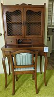 Front view of the vintage wooden secretary desk and matching chair with upholstered seat and backrest, showing overall design and finish