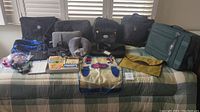 Full overview of all travel items including bags, pillows, packing cubes, and accessories arranged on bed