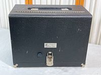 Closed black Pachmayr gun case with carrying handle on top, metal latch, and small scuffs visible on the surface.