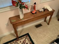 Full view of the antique hall table showing its length and decorative items on top.