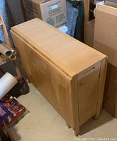 Table closed, leaves folded down, chairs stored inside base