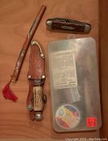 Photo of two pocket knives, one with Boy Scout label, and fixed blade knife with leather sheath plus plastic tackle box