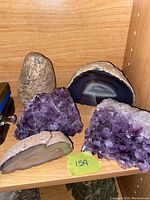 Front view displaying all items: rock vase, two amethyst clusters, two agate slices