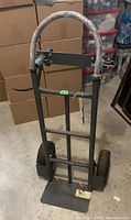 Full view of the Ultra heavy duty convertible hand truck showing metal frame, dual wheels and handle wrapped in protective covering.