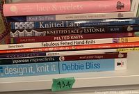 Front view of the stacked knitting books showing spines and titles for identification.
