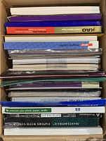 Stack of assorted printer paper packages including specialty and standard sheets