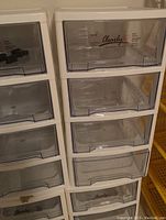 Close-up photo showing two plastic storage units side by side with four clear drawers each, labeled 'Clearly'.