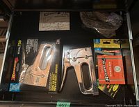 Two Arrow T50 staple guns with one in original packaging and several boxes of staples in different sizes and packaging.