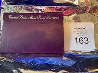 Purple faux-leather outer case with 'United States Mint Proof Set 1990' gold embossed on front, showing some cracking.