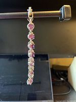 Clear view of the full bracelet hanging vertically showing round purple CZ stones with clear CZ accents in sterling silver setting.