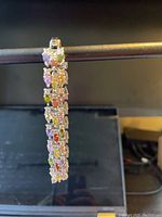 Close-up side view of the sterling silver bracelet showing multicolor CZ stones arranged in clusters.