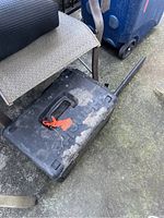 Plastic hard carrying case with embossed Homelite logo, handle, and latch. Dust and dirt visible on surface.