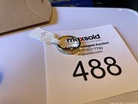 Photo showing the front and side angle of a size 6 gold vermeil over sterling silver ring with tag showing size 6 and maxsold auction number 488.