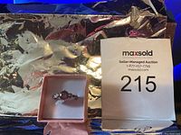 Ring viewed from the top showing the gemstone and band design in a pink box.