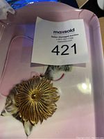 Front view of vintage Monet floral brooch showing textured petals and blue center stone.