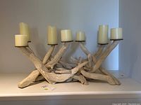 Full view of wooden candle holder with 7 candle stands, natural driftwood style wood and ivory pillar candles.