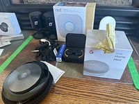 Overview showing all lot contents: boxed Google Home Mini, boxed Nest Protect, EOZ charging case with earbuds, Jabra Bluetooth speaker and cables