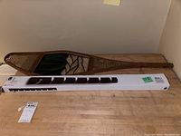 Full view of snowshoe on tabletop with white box beneath for scale.