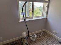 Full view of the two steamers side by side showing the Rowenta pressure iron in white and Kobe Deluxe steamer with metal base and flexible hose.