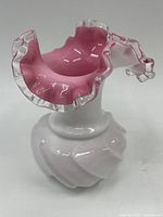 View of the pink and white ruffled glass vase showing the delicate ruffled edge with clear glass trim.