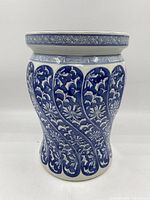 Front view of the large ceramic base showing blue floral swirling pattern on white background with geometric band near top.