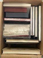 Overhead view of cardboard box filled with assorted books and journals
