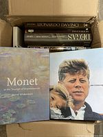 Top view of box with visible book titles including Monet and John F. Kennedy