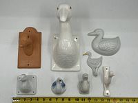 All 8 ceramic duck ornaments laid out with measuring scale showing size reference