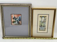 Two framed vintage watercolours displayed side by side with a measuring tape below for scale.