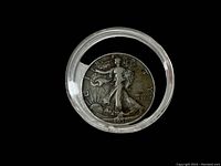 Front obverse image of the 1938 D Walking Liberty half dollar coin in clear plastic case, showing detailed coin design and condition under light.