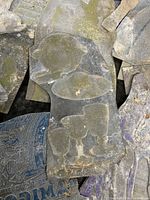 Close-up view of a single antique metal printing plate showing embossed imagery, wear, and oxidation.